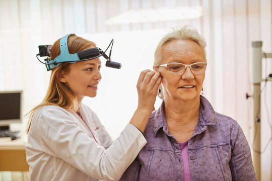 ENT physician examining ear of a senior woman