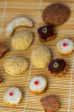 Various kinds of tasty Christmas chocolate, nuts and filled cookies on japanese wooden mat