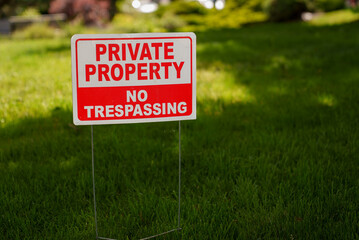 "Private Property No Trespassing" sign placed outdoors on lawn to keep trespassers away from property line. © Hamilton Productions
