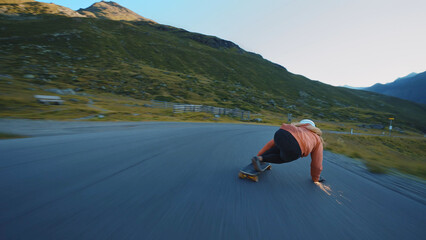 woman skateboarding and making tricks between the curves on a mountain pass. © oneinchpunch