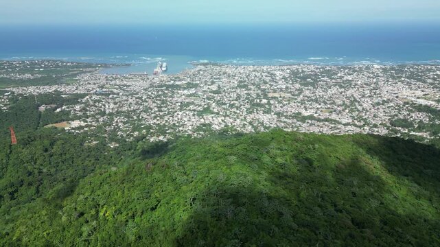 Spectacular aerial panorama of Puerto Plata, Dominican Republic, captured from above Mount Isabel de Torres. The drone reveals the city, Atlantic coastline, tropical hills and Caribbean landscape