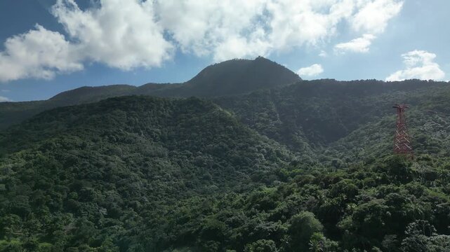 Drone footage showcasing the spectacular panoramic landscape from Mount Isabel de Torres in Puerto Plata, Dominican Republic. Lush tropical rainforest covers the mountainside
