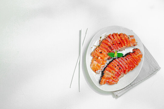 Sliced salmon fillet served on a ceramic plate, diet food concept. Healthy premium seafood