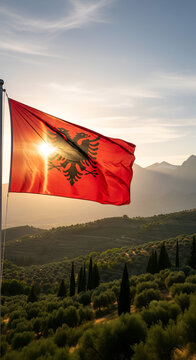 Sunlight shining through albanian flag over terraced hill landscape