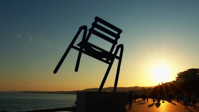 4K French Riviera Nice beautiful tracking shot with silhouettes of people walking on the seaside at sunset slow motion 