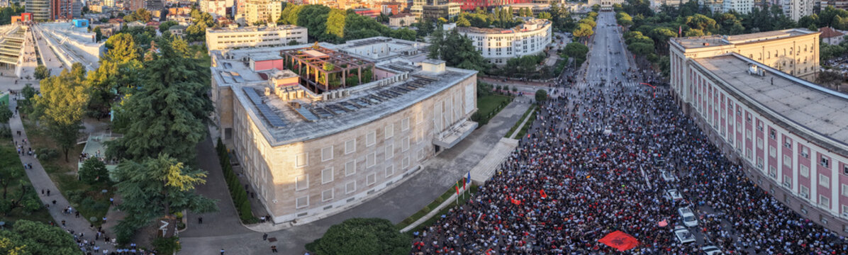 protest outside government buildings in central Tirana, with demonstrators, police vehicles and city architecture visible during a civic action connected to Zv&euml;rnec, Narta and flamingo protection.