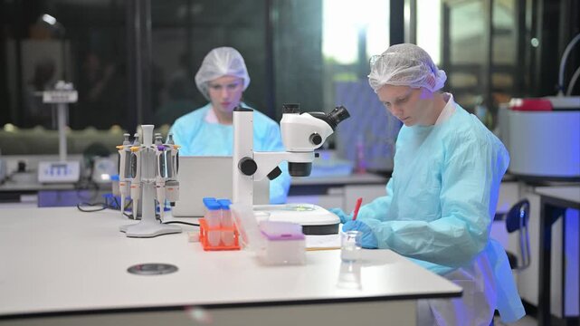 Lab work in progress with scientists using a microscope and preparing samples