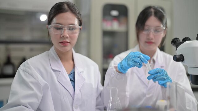 Students conduct experiments in a science lab wearing lab coats and safety goggles with equipment