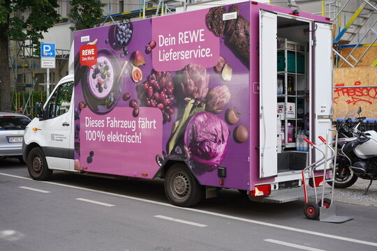 Elektrischer Lieferwagen des REWE Lieferservices parkt mit ge&ouml;ffneter Heckklappe in der Stra&szlig;e Alt-Treptow. Am Heck steht eine Sackkarre f&uuml;r die Zustellung bereit. Berlin, 05.06.2026