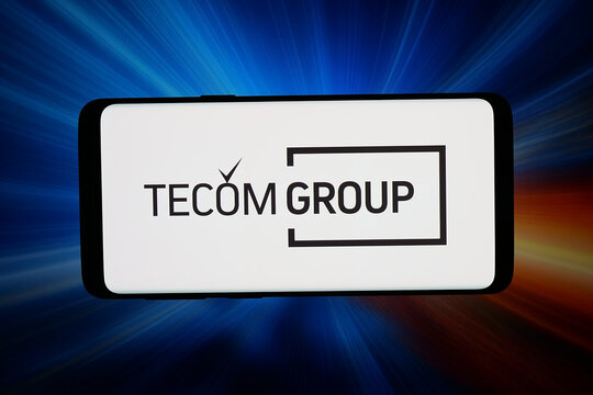 Stuttgart, Germany - 05-20-2026: In this photo illustration, the logo of Emirati real estate company TECOM Group PJSC is displayed on a smartphone in front of abstract background on computer screen.