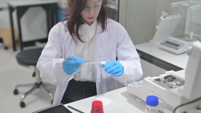 Scientist measures samples in laboratory for research study on chemical properties