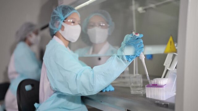 Laboratory work in progress with scientists using pipettes in a clean environment