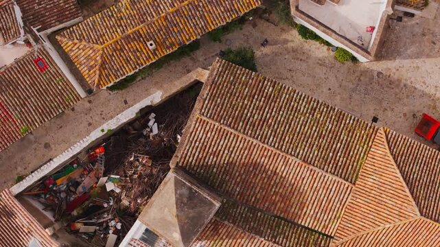 Aerial view of the historic terracotta tiled rooftops and narrow stone streets of Castellar Viejo in Castellar de la Frontera, Andalusia, Spain.