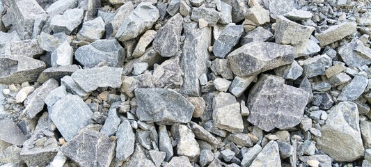 Fototapeta premium Volcanic mountain stones pile for heavy construction. Raw rugged mineral background for real estate and infrastructure development