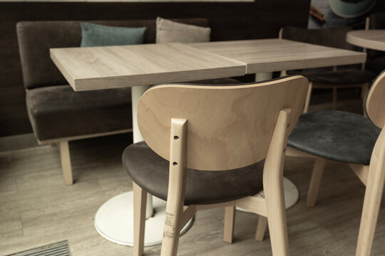 Empty wooden table and chairs in modern cafe interior