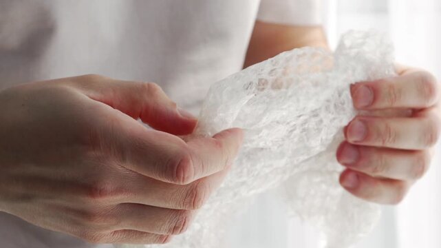 A man crumples protective film with soft bubbles in his hands.
Bubble-sealed film for parcels.