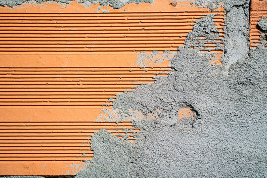 Textura de muro de ladrillo rojo con aplicaci&oacute;n de mortero y acabado de construcci&oacute;n en primer plano