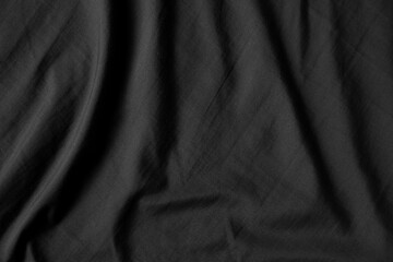 Fototapeta premium Close up black wrinkled fabric texture rippled surface, Soft focus.