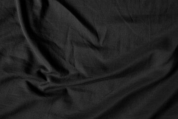 Fototapeta premium Close up black wrinkled fabric texture rippled surface, Soft focus.