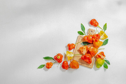 Culinary background of assorted fresh chili peppers arranged on a wooden cutting board