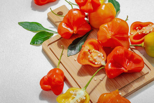 Culinary background of assorted fresh chili peppers arranged on a wooden cutting board