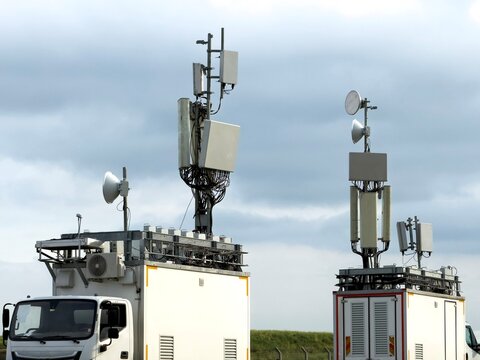 View of mobile telecommunication base stations mounted on white trucks with various antennas and satellite dishes under a cloudy sky Besiktas, Istanbul, Turkey.