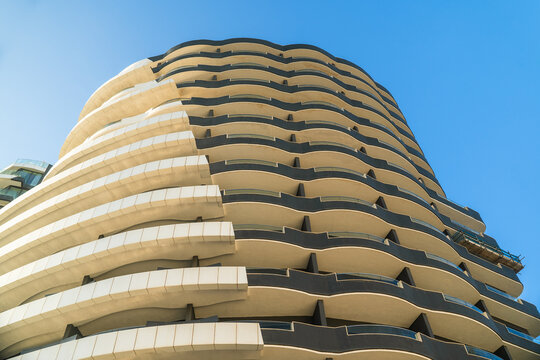 View of modern residential building with curved balconies and contemporary architecture under a clear blue sky Sliema, Eastern Region, Malta.