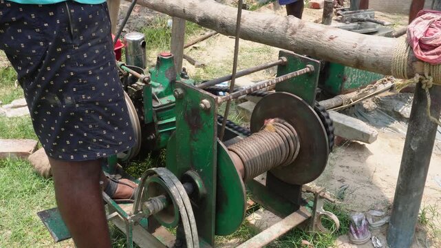 Manual Drilling Rig with Wooden Lever in Rural Setting