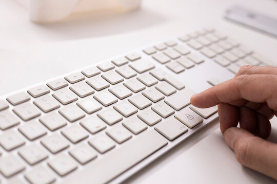 Finger pressing lock security button on keyboard