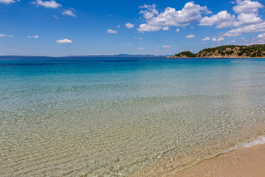 Beach with a boat in the water and a mountain in the distance, Ammoulliani, Greece