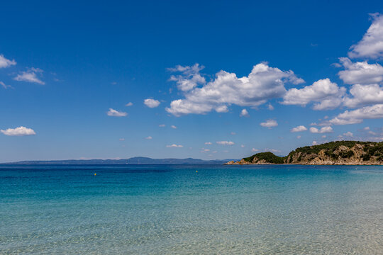 Beach with a boat in the water and a mountain in the background, Ammoulliani, Greece