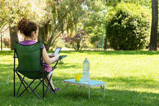 A woman reading in a camping chair