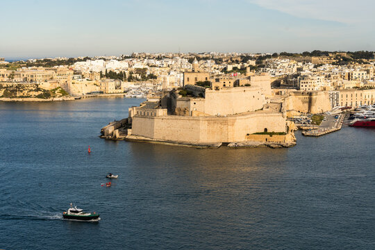 View of the historic Fort Saint Angelo bastions overlooking the Grand Harbour with boats on the water in Valletta, Port Region, Malta.