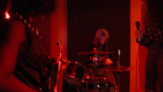 Multiethnic teenage girls playing rock music during rehearsal in creative studio. Clip is ideal for youth culture campaigns, music school promotions, or entertainment advertisements