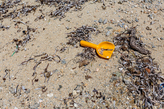 Yellow spoon toy abandoned forgotten on the beach, Ammoulliani, Greece
