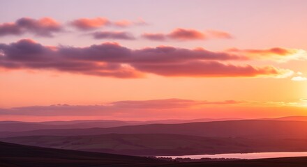 Obraz premium Scenic sunset over rolling hills and distant mountains vibrant sky