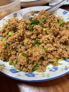 Spicy pork larb. Larb moo. Thai food. Isan food. Homemade food. Home cooking. Traditional Thai food. Asian food. Minced pork. Spicy salad. Homemade meal. Fresh herbs.