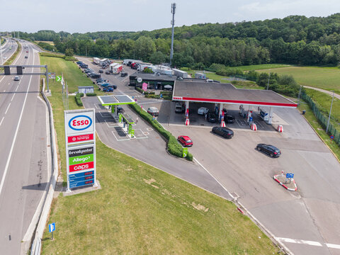 30 May 2026, Rotselaar, Belgium. Aerial drone view of highway fuel station with price sign, EV charging and truck parking on E314 motorway