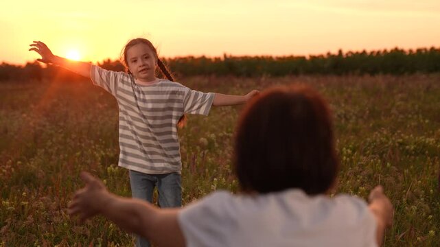 A little girl runs to her mother at sunset, Family reunion in the field, Warm sunset embrace, Joyful child in nature, Mother and daughter happy moment, Open arms and big smiles, Summertime meadow