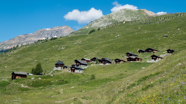Beautiful alpine village with traditional dark wooden chalets and a small chapel on a green hill in Lauchernalp, Loetschental valley, Valais, Switzerland.