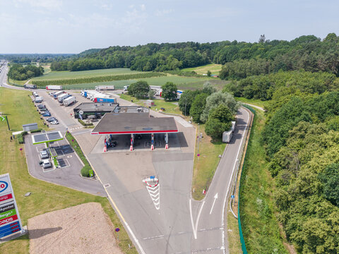 30 May 2026, Rotselaar, Belgium. Aerial drone view of highway service station exit with fuel pumps, EV chargers and truck parking along E314