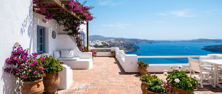 Terrasse ensoleill&eacute;e avec fleurs face &agrave; la mer &agrave; Santorin