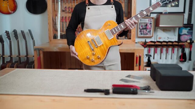 Guitar Technician Inspecting Electric Guitar After Repair and Setup
