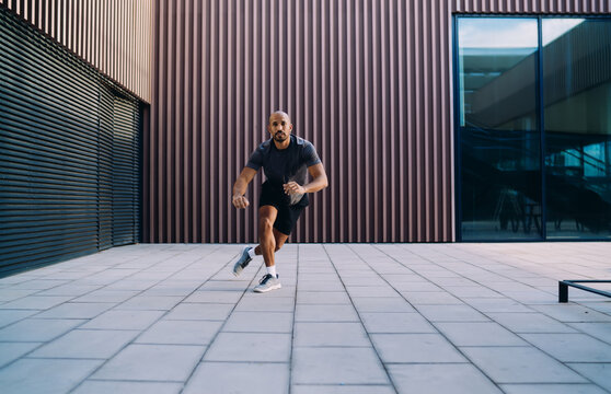 Handsome sportive man in athletic wear doing workout exercise, athlete enjoying an outdoor run session in city, fitness motivation and urban wellness