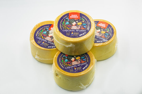Hanul Boieresc Cascaval Afumat cheese wheels pile closeup on white.