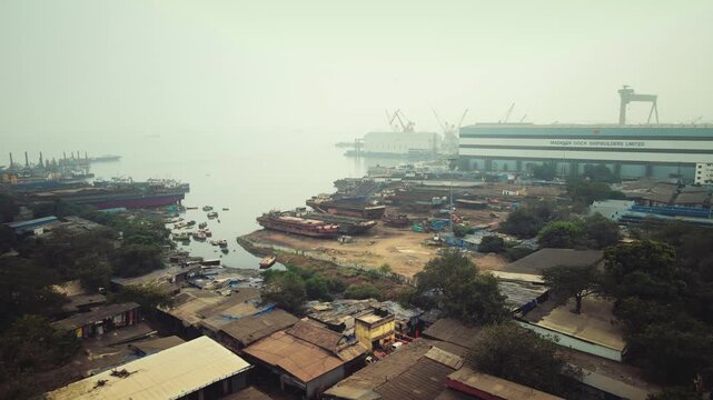 Aerial view of Sewri village near the Dockyard area in Mumbai, India, capturing a striking contrast between traditional coastal settlements and industrial port infrastructure.