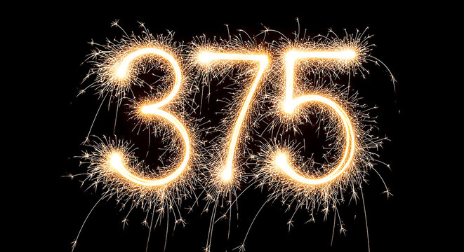 Vibrant fireworks explosion creating the number 375 in bright golden sparks against a black backdrop, ideal for celebrations or milestones.