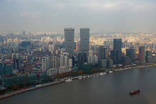 View of the Shanghai IFC towers and modern skyline along the Huangpu River under a hazy sky Shanghai, Shanghai, China.