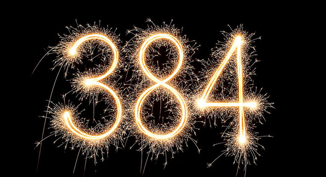 Vibrant sparkler fireworks arranged in the shape of the year 384, glowing brightly against a dark night sky background.