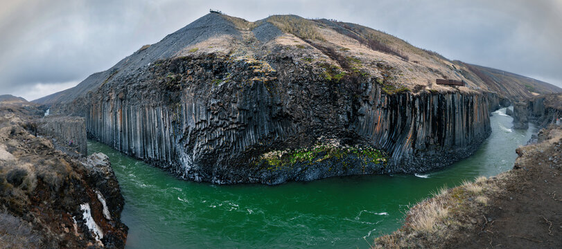 View of Studlagil Canyon with its unique basalt columns and the turquoise Jokulsa a Dal river under a cloudy sky in Eiriksstadhir, Mulathing, Iceland.